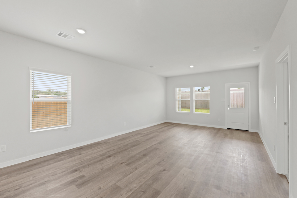 A room with a wood floor and windows.