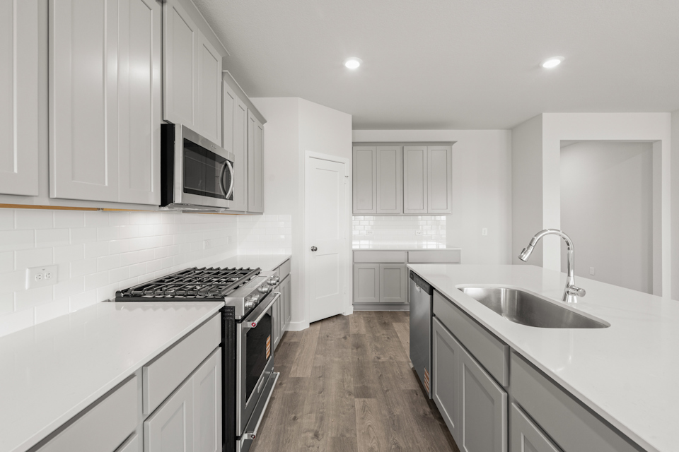A kitchen with white cabinets.