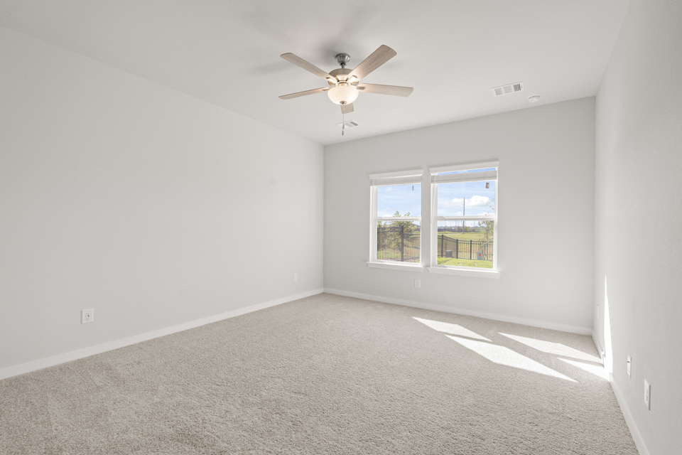 A room with a ceiling fan and a window.