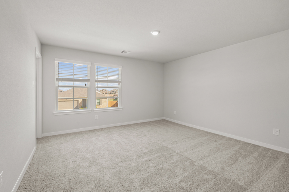 A room with a window and a carpet.