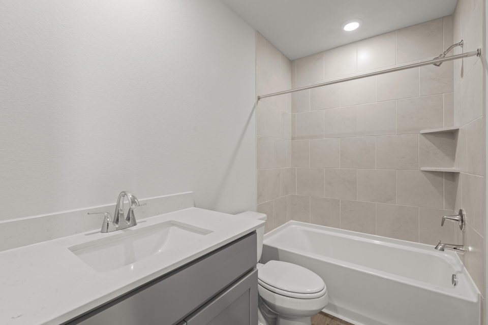 A bathroom with a tub sink and toilet.