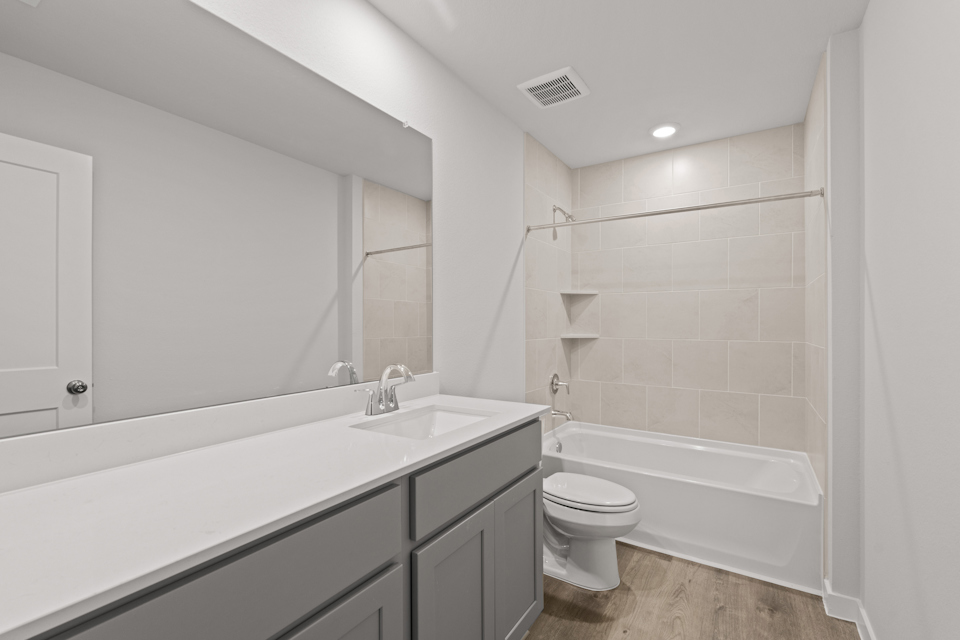 A bathroom with a tub sink and toilet.