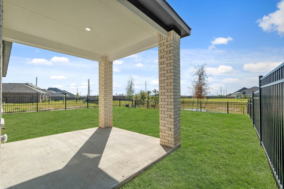 A view of a grass yard and a fence.