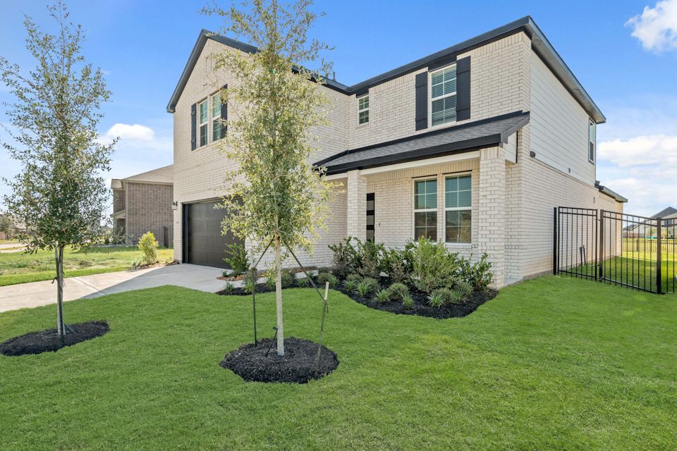 A large house with a lawn and trees in front of it.