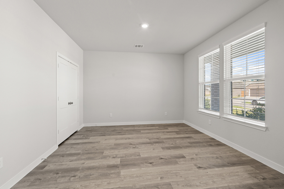 A room with a wood floor and windows.