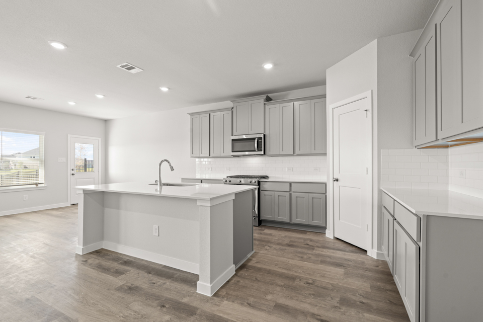 A kitchen with white cabinets.