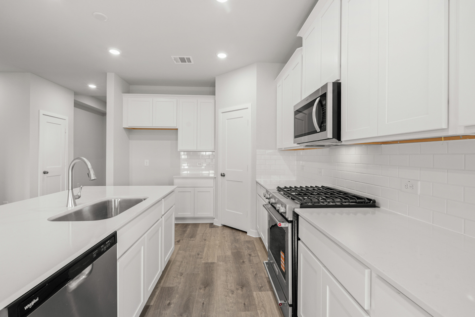 A kitchen with white cabinets.