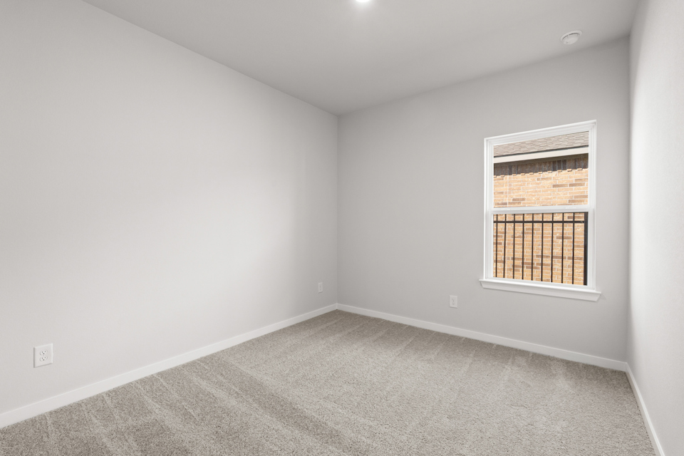 A room with a window and a carpet.