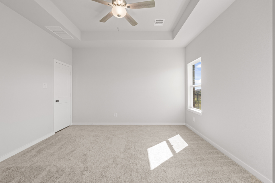 A room with a ceiling fan and a door.