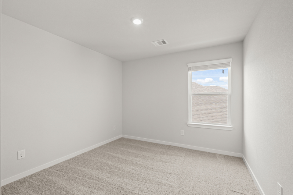 A room with a window and a carpet.