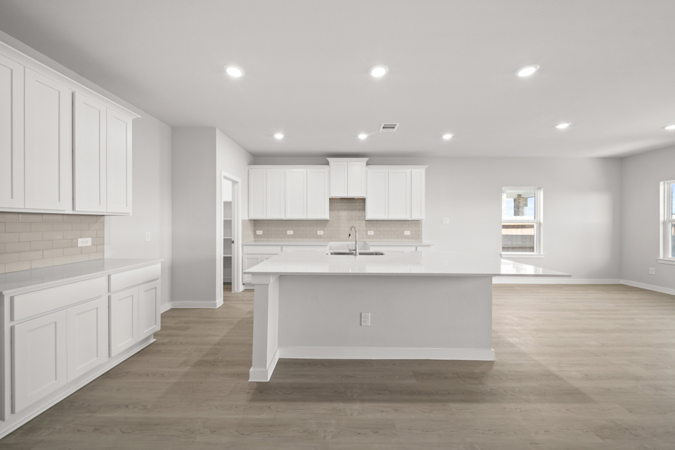 A kitchen with white cabinets.