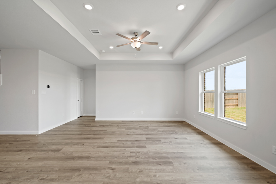 A room with a wood floor and a ceiling fan.