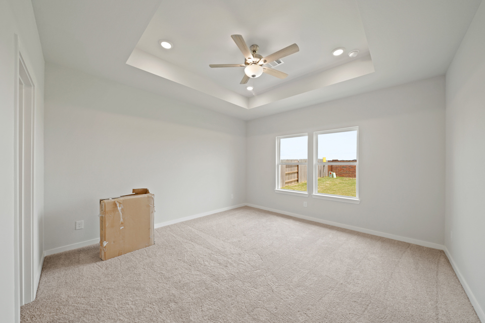 A room with a ceiling fan and a suitcase.