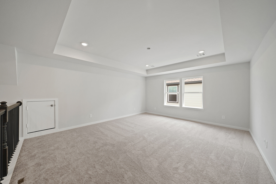 A room with a carpet and windows.