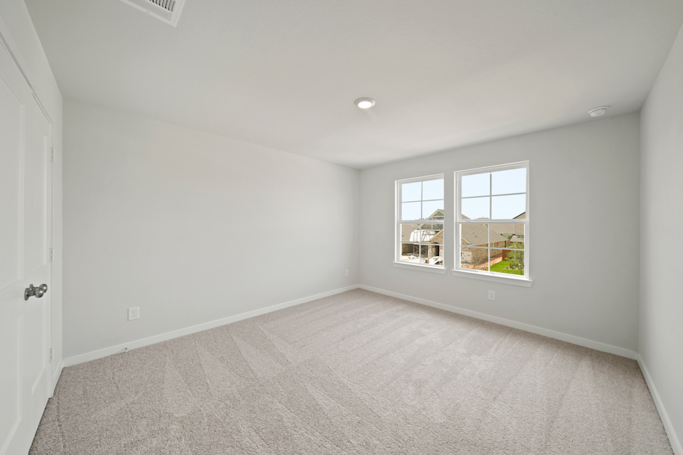 A room with a window and a carpet.