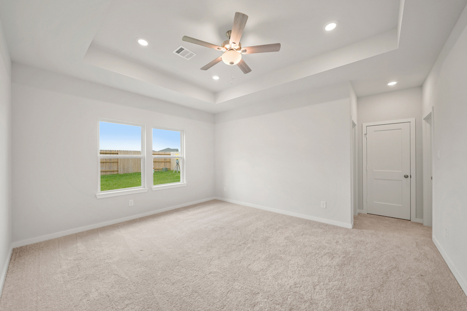 A room with a ceiling fan and a window.