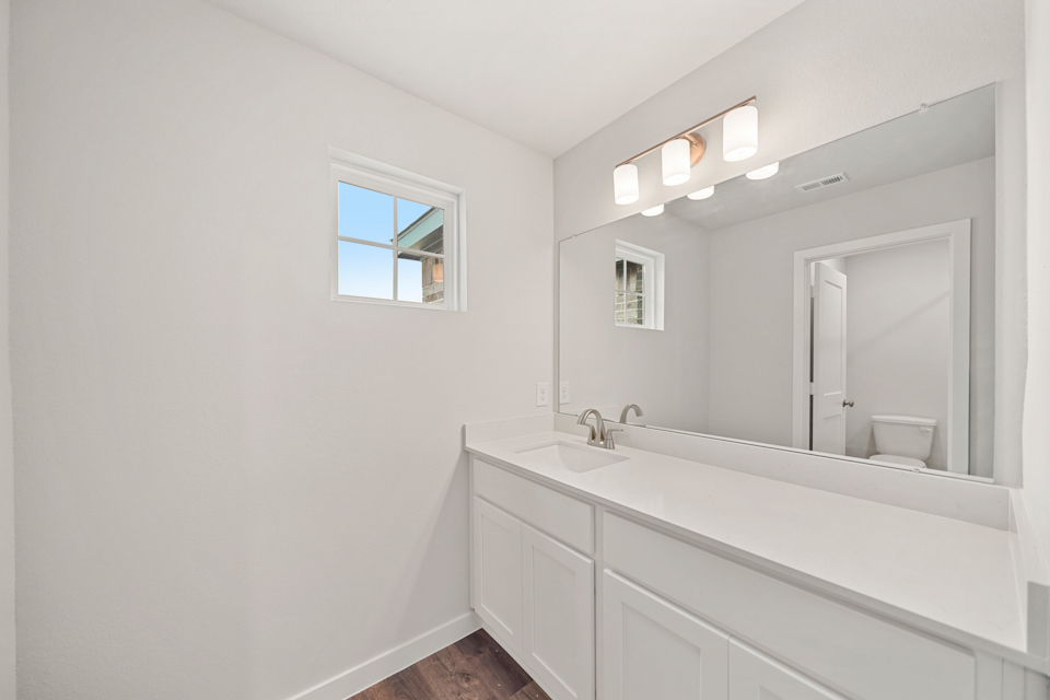 A bathroom with a large mirror.