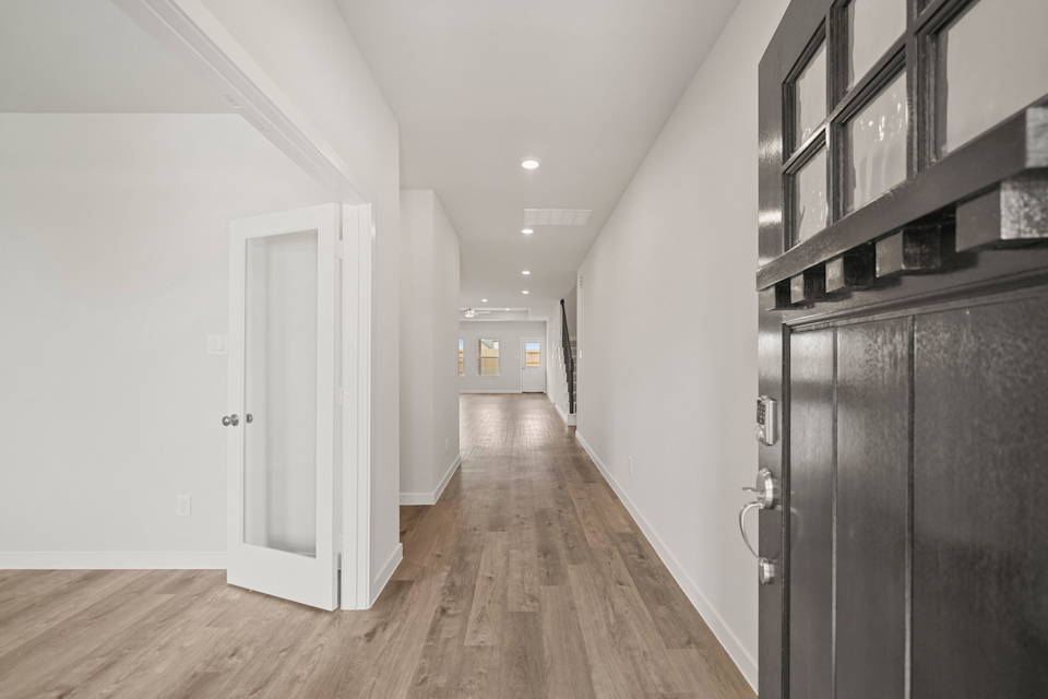A hallway with black cabinets.