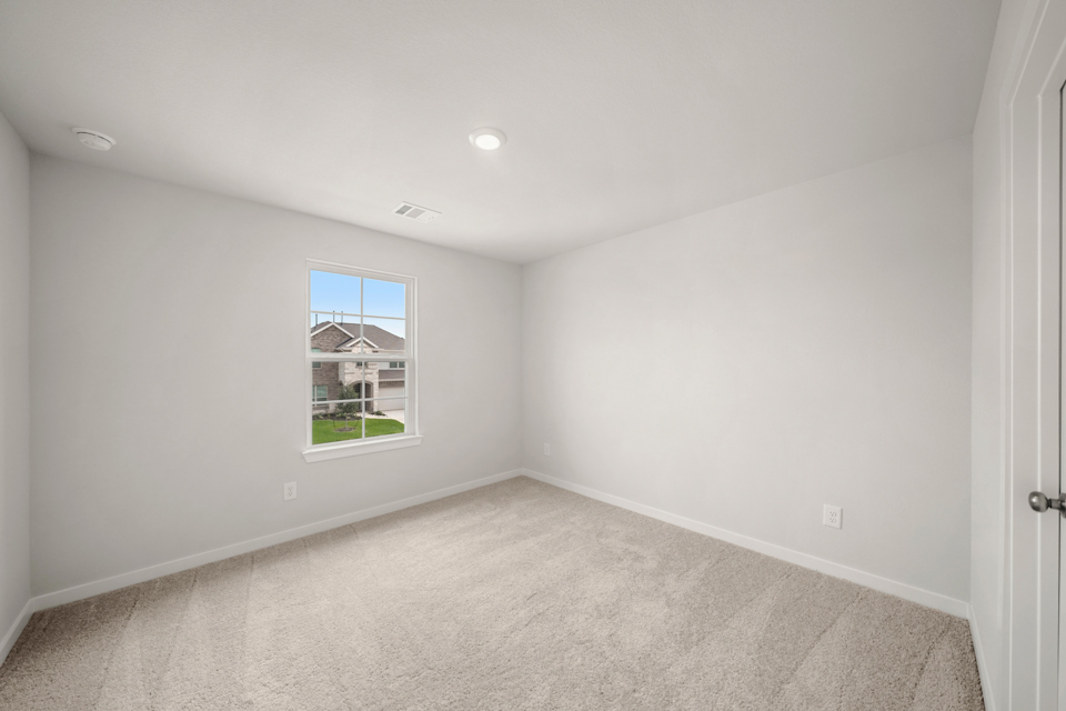 A room with a window and carpet.