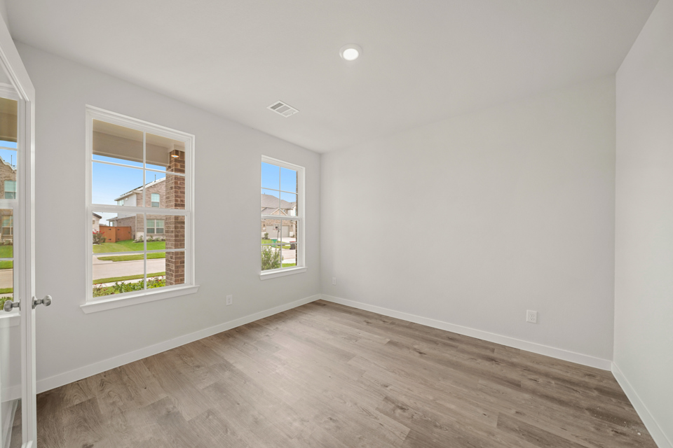 A room with a wood floor and windows.