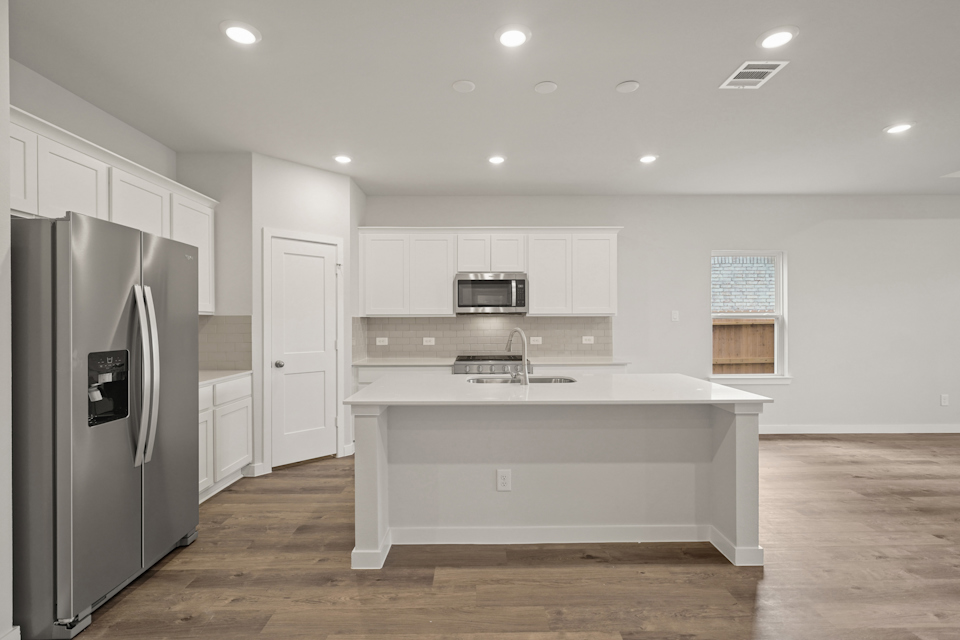 A kitchen with white cabinets.