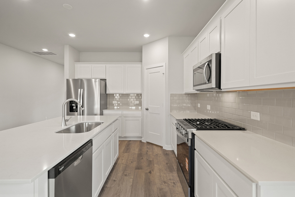 A kitchen with white cabinets.