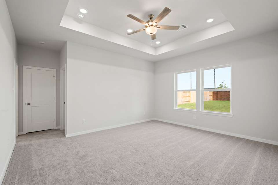 A room with a ceiling fan and a door.
