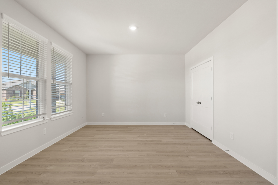 A room with a wood floor and windows.