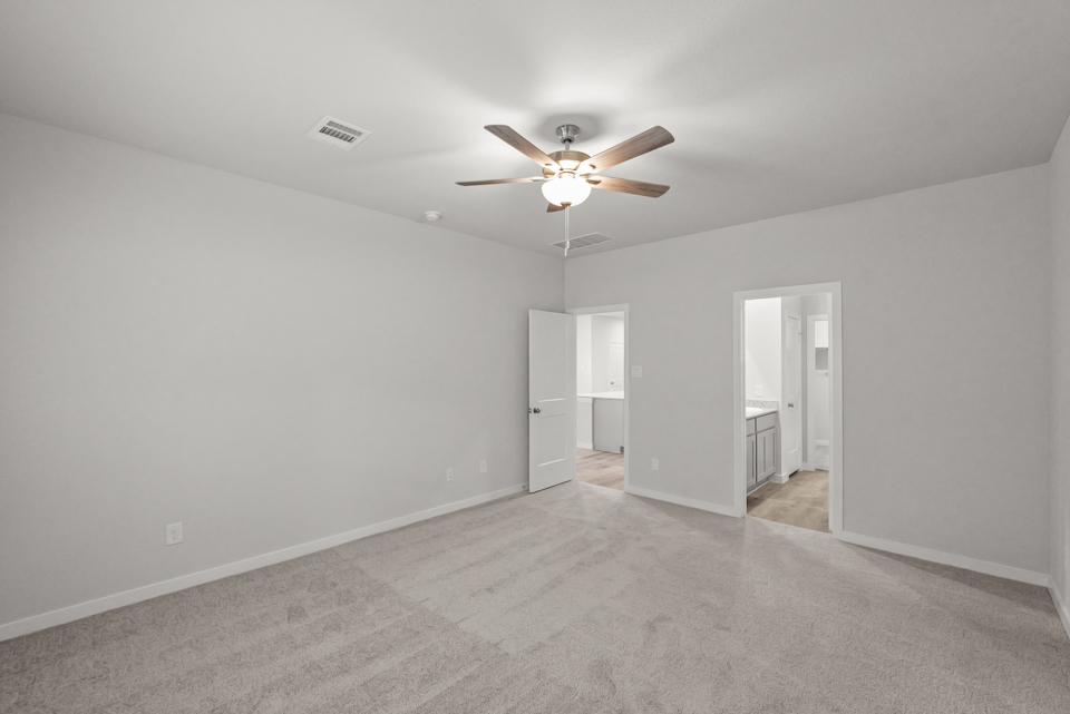 A room with a ceiling fan and white walls.