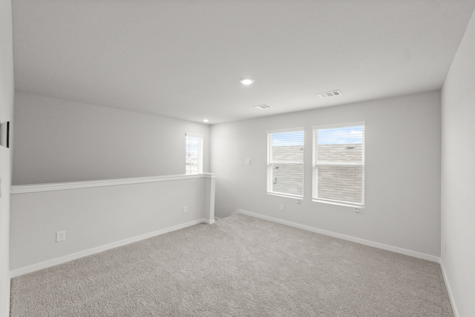 A room with a carpet and a white wall.