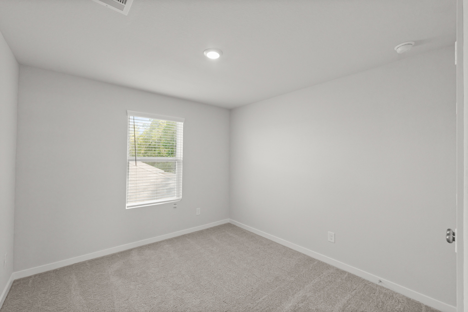 A room with a window and a carpet.