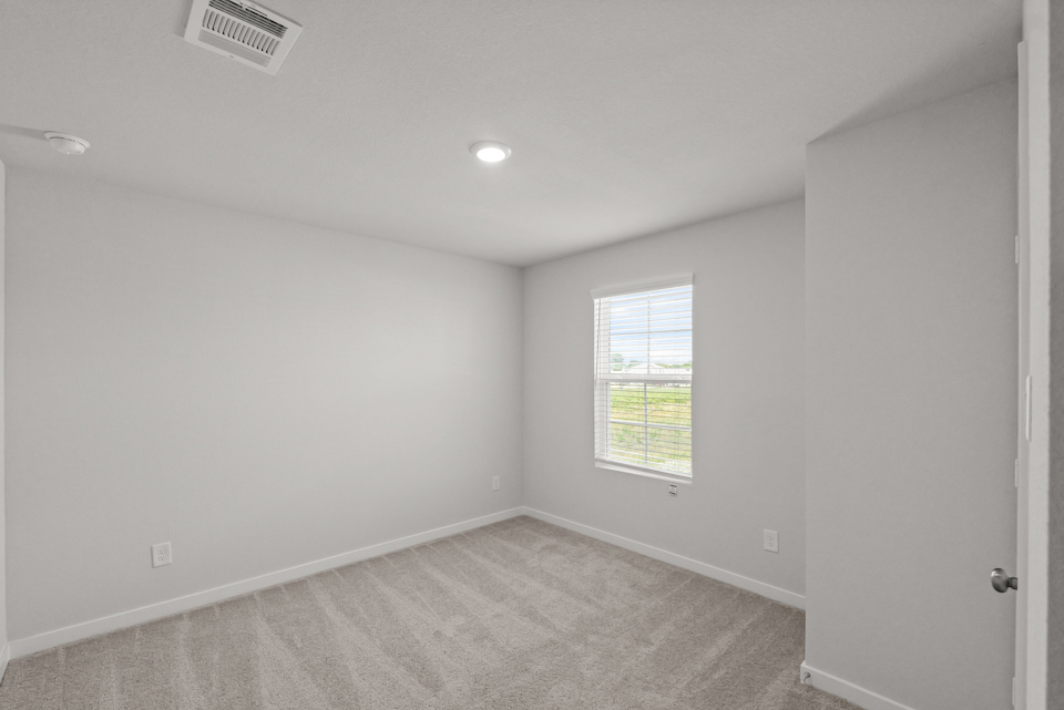 A room with a window and a carpet.