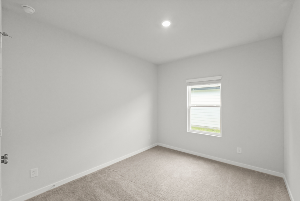 A room with a window and a carpet.