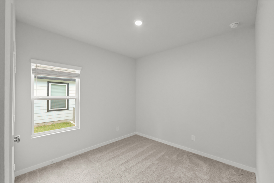 A room with a window and a carpet.