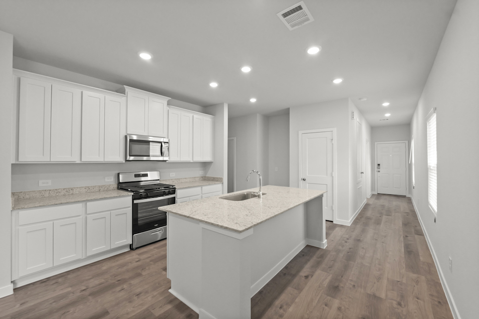 A kitchen with white cabinets.