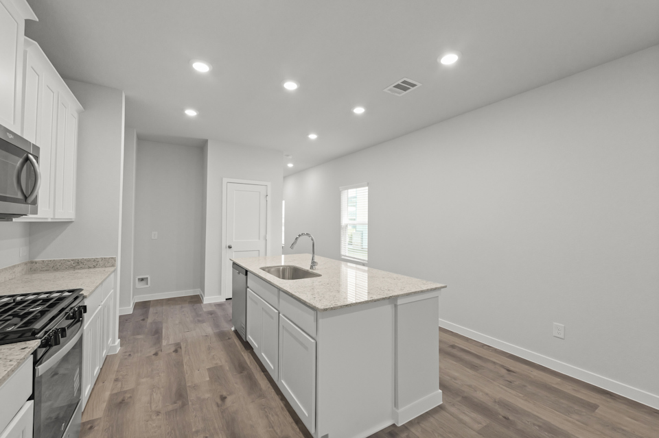 A kitchen with white cabinets.