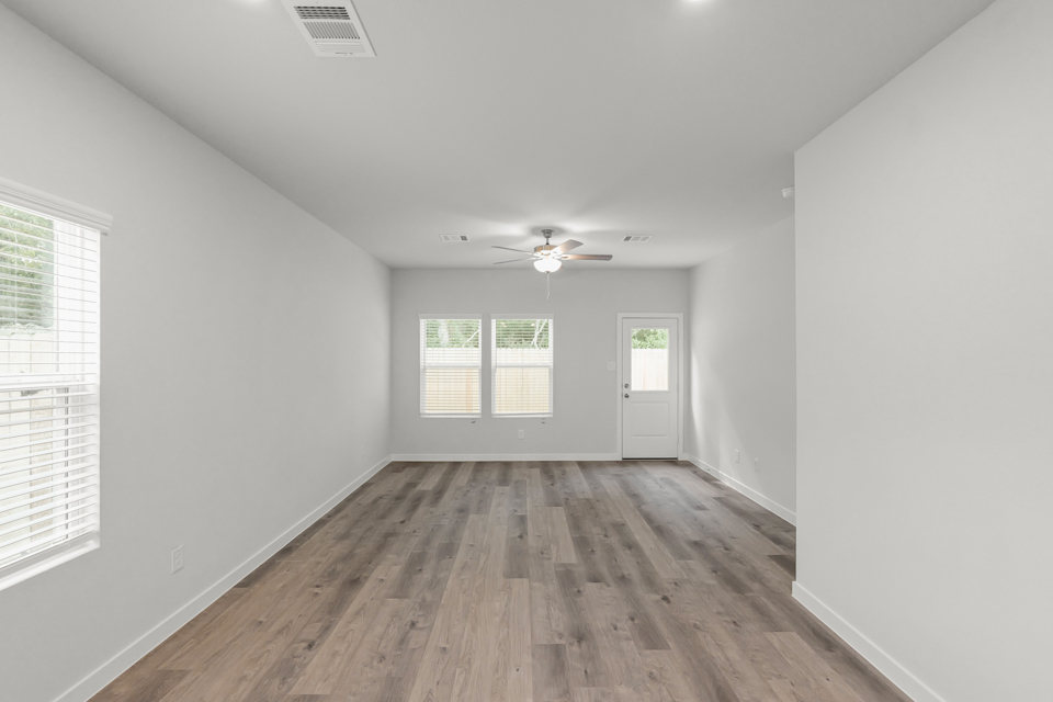 A room with a wood floor and a ceiling fan.