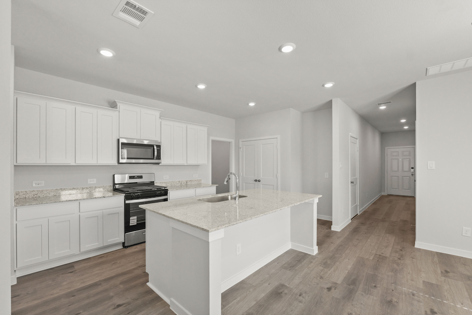 A kitchen with white cabinets.
