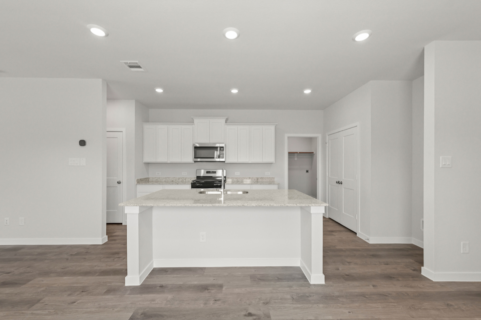 A kitchen with white cabinets.