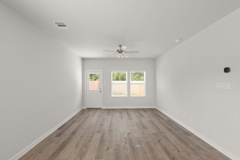 A room with a wood floor and a ceiling fan.