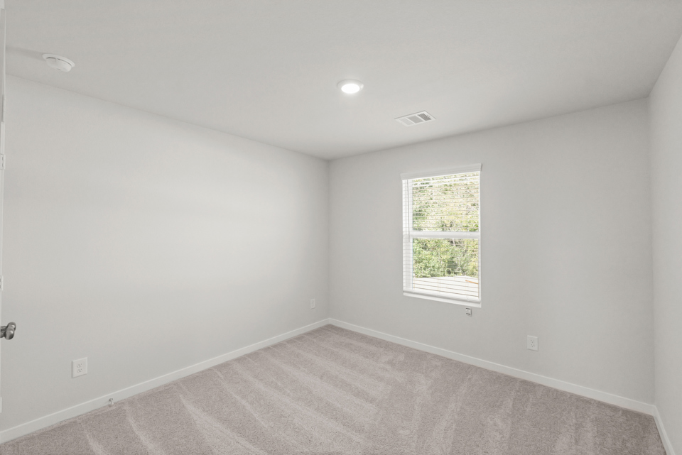 A room with a window and a carpet.