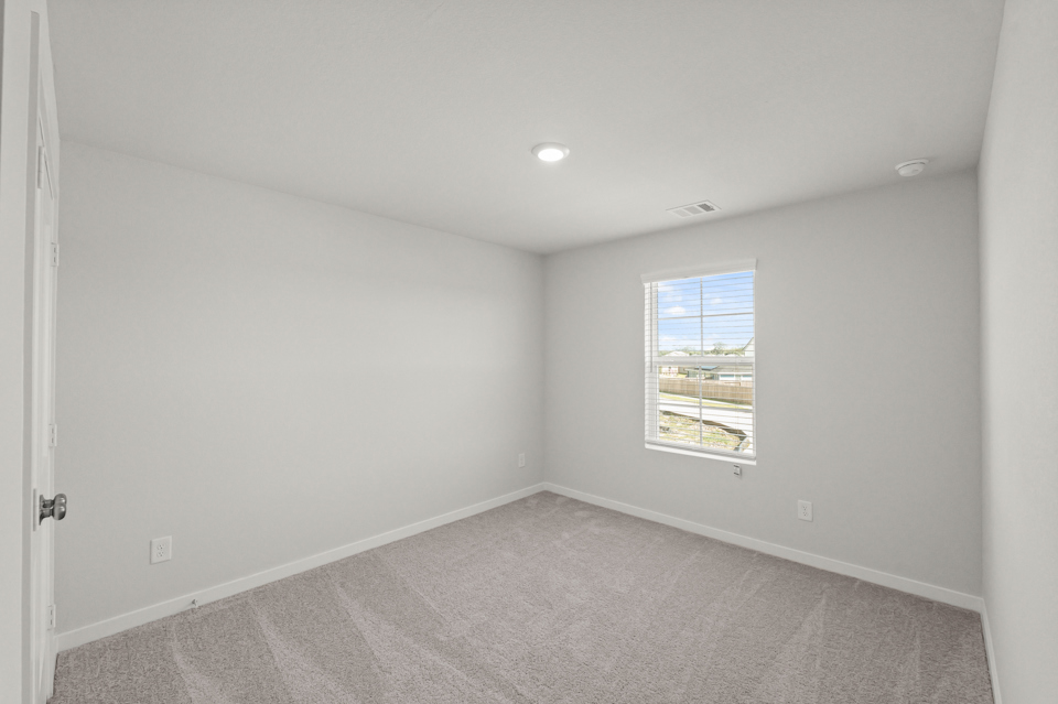 A room with a carpet and a window.