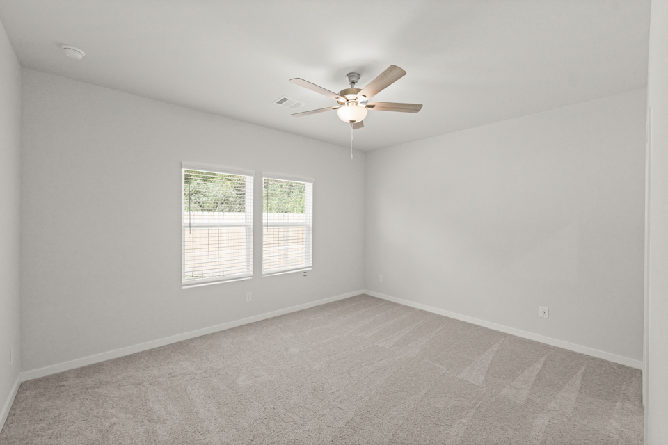 A room with a ceiling fan and a window.