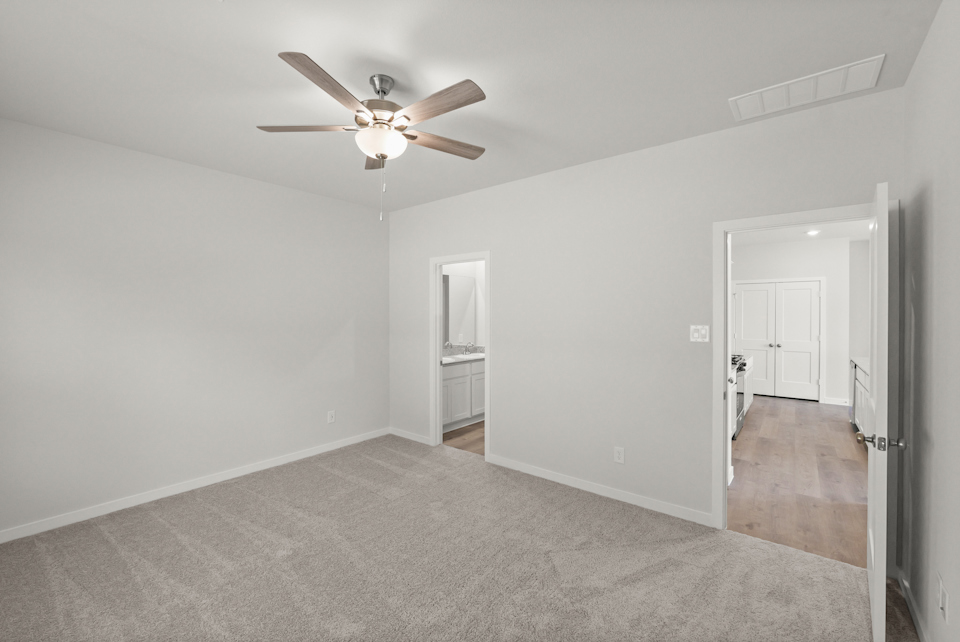A room with a ceiling fan and a door.