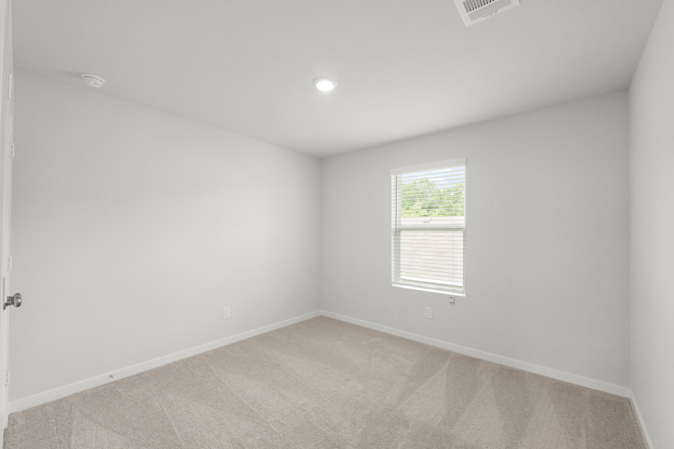 A room with a window and a carpet.