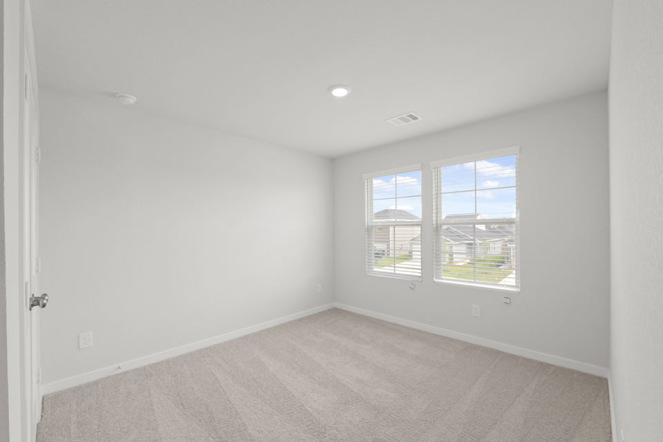 A room with a window and a carpet.