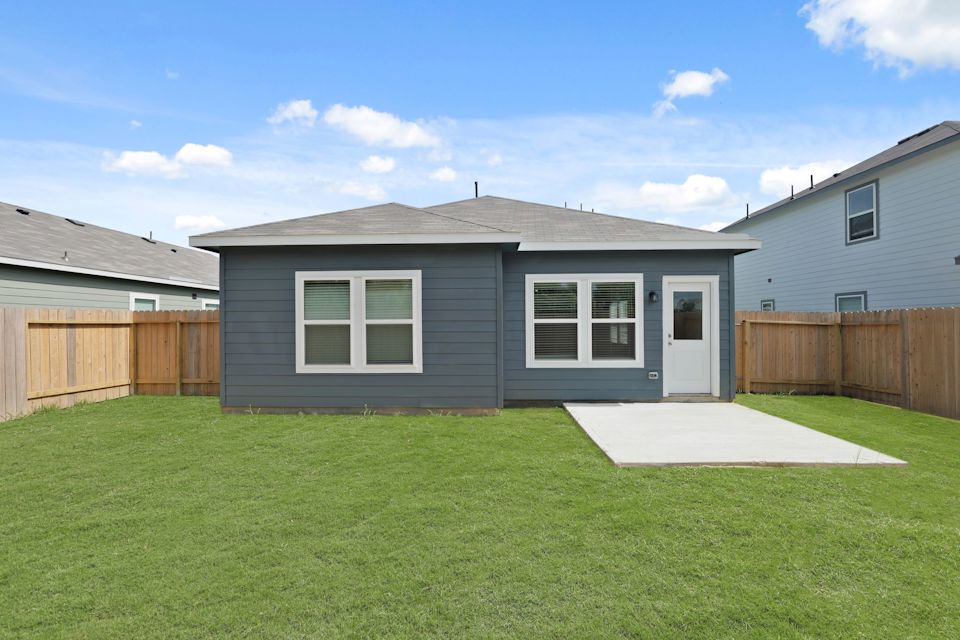 A house with a fence and grass.