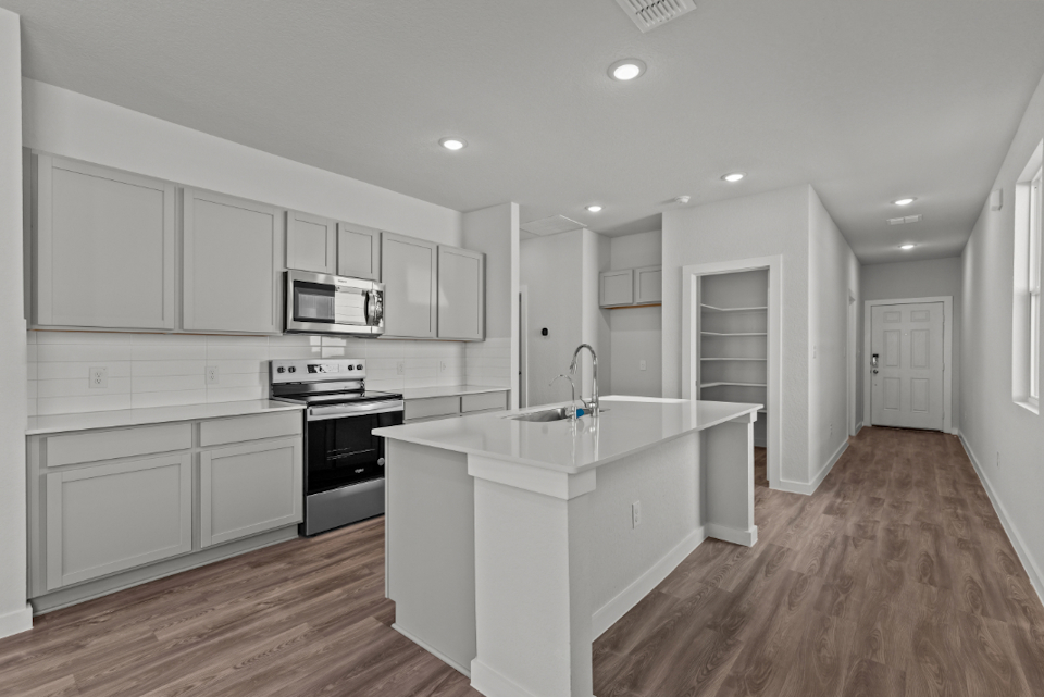 A kitchen with white cabinets.