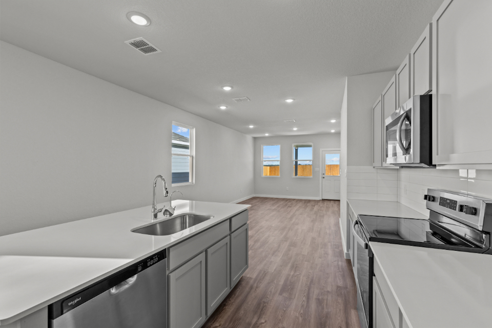 A kitchen with white cabinets.