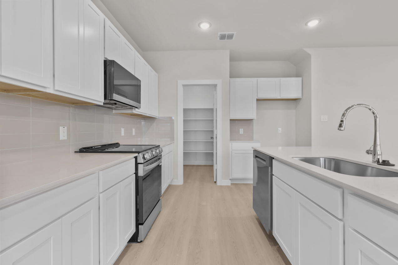 A kitchen with white cabinets.
